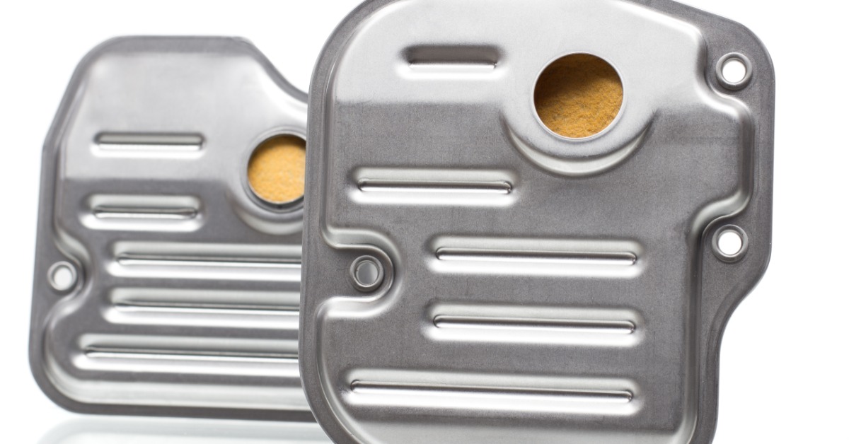 Two silver transmission filters stand against a white background. Both have holes revealing yellow mesh inside.